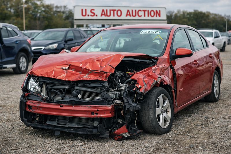 Damaged car with salvage title sitting in a U.S. auto auction lot after being declared a total loss.